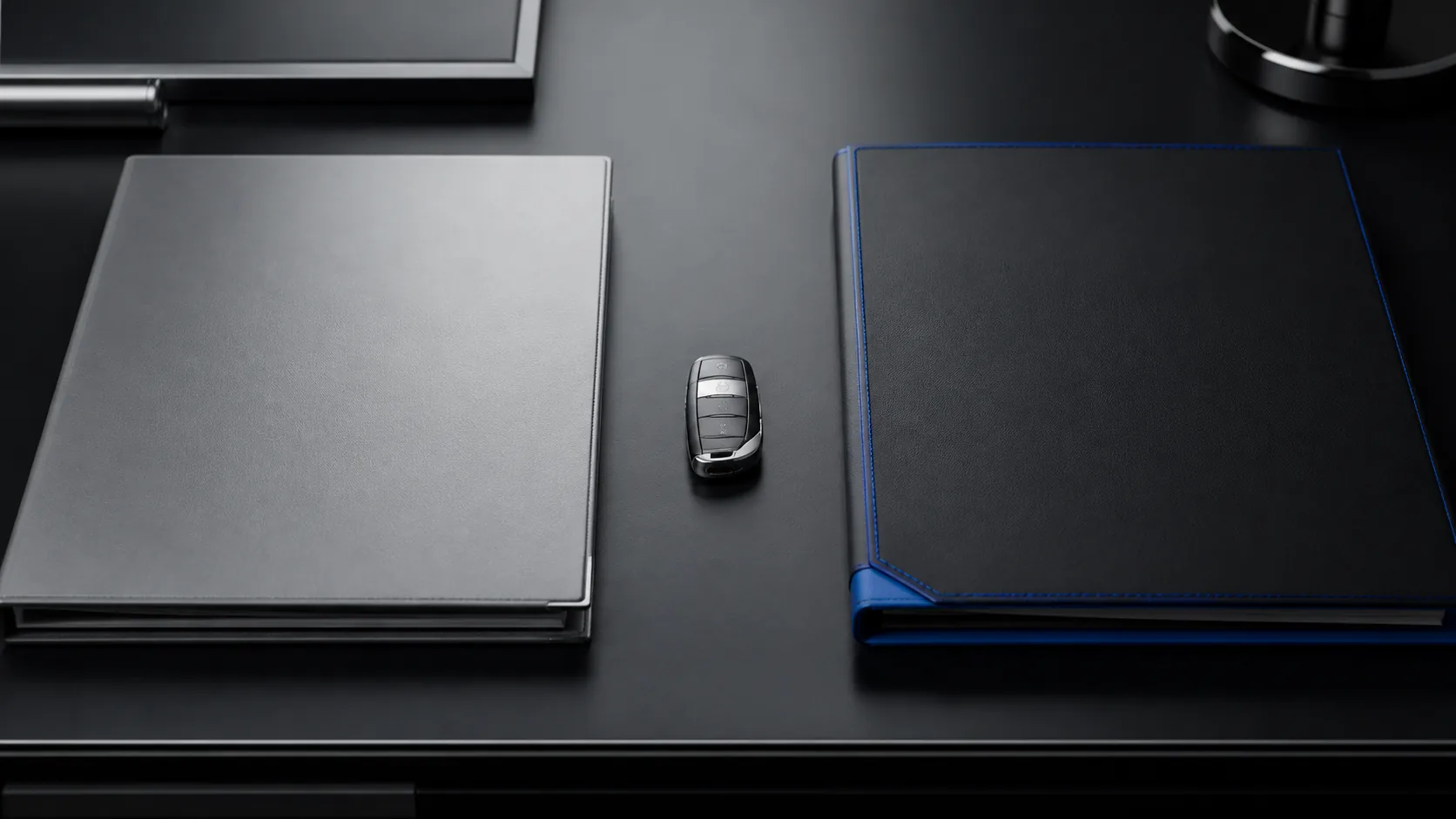 Two blank vehicle contract folders beside an unbranded car key